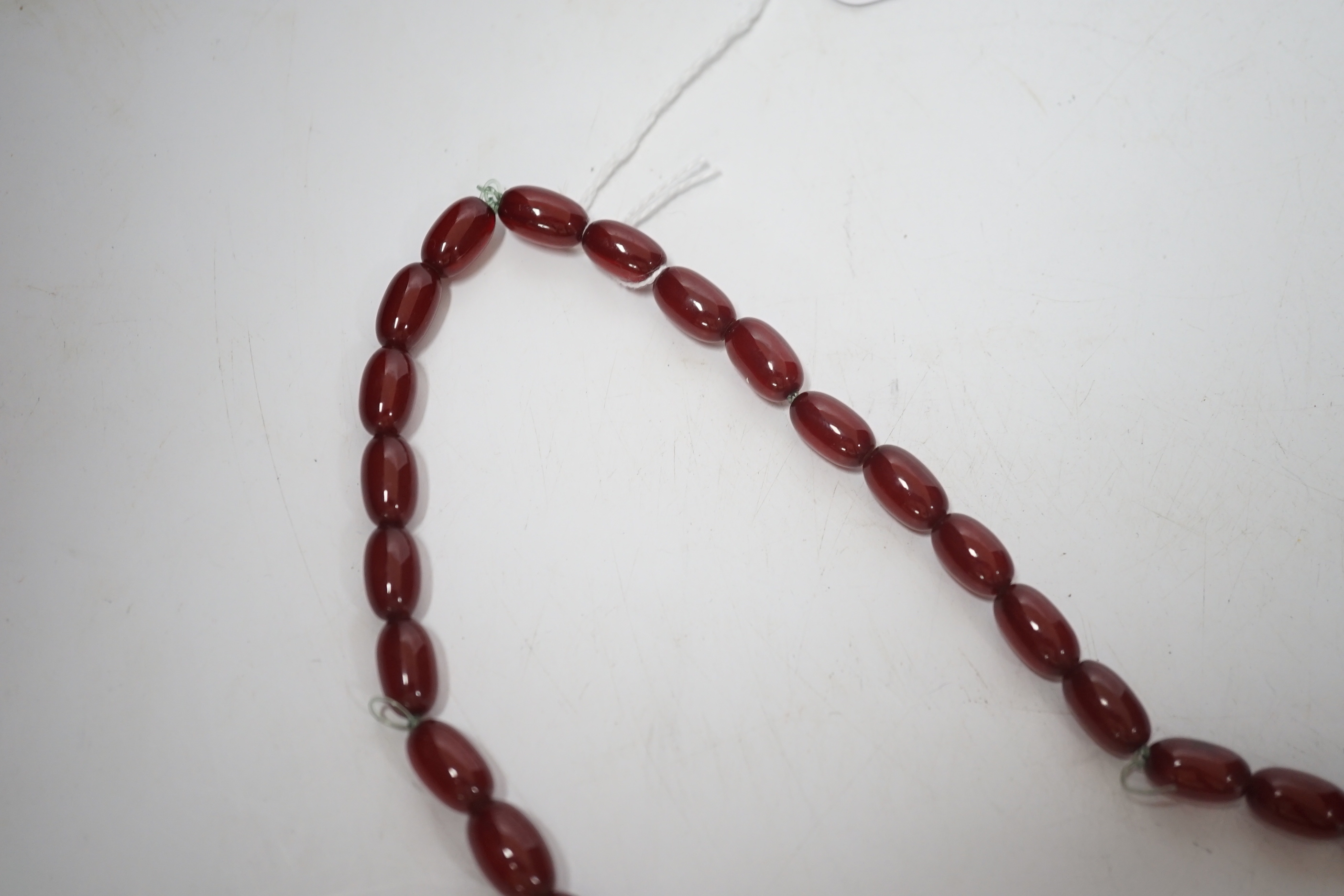 A single strand graduated oval simulated cherry amber bead necklace, 70cm, gross weight 63 grams.